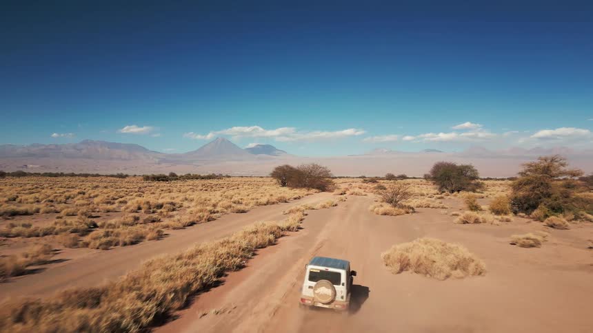 A vehicle drives through a desert