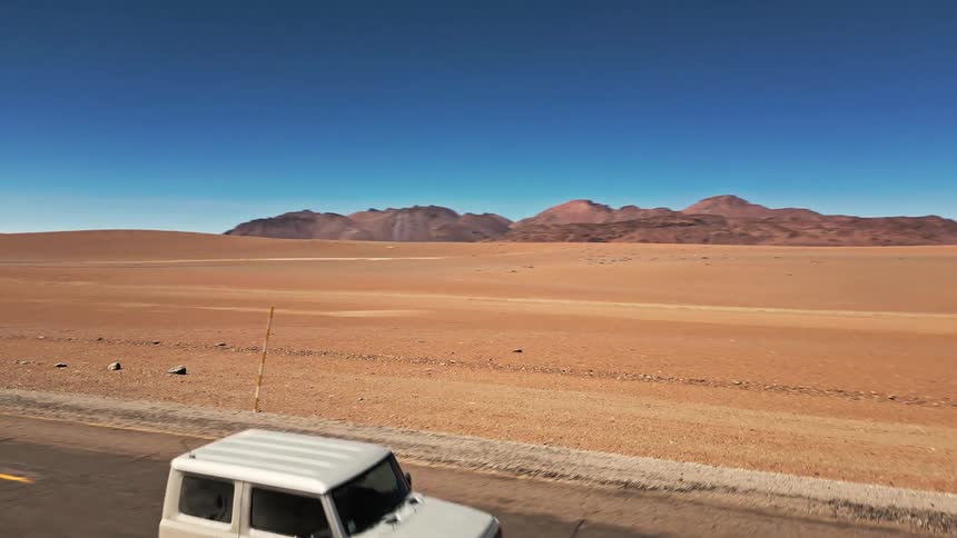 A truck drives down the road through the desert