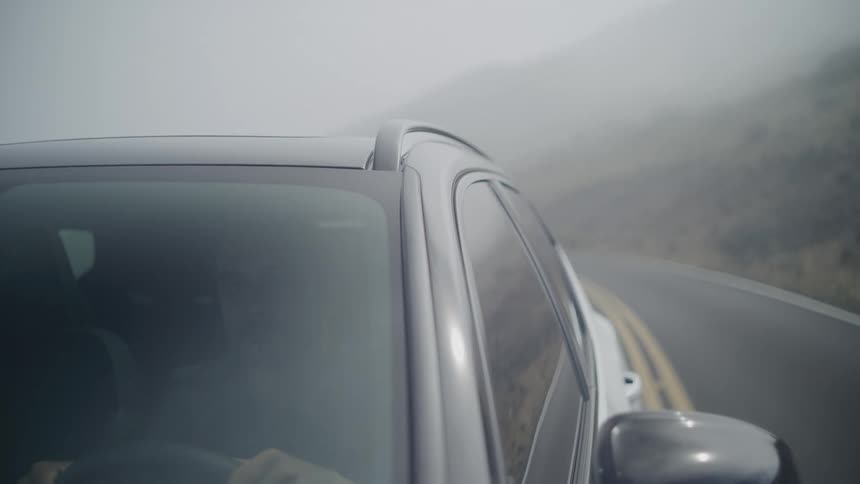 Man drives a car on the freeway on a foggy day