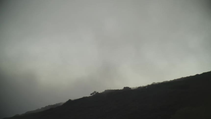 A gloomy mountain landscape under a cloudy sky at dawn