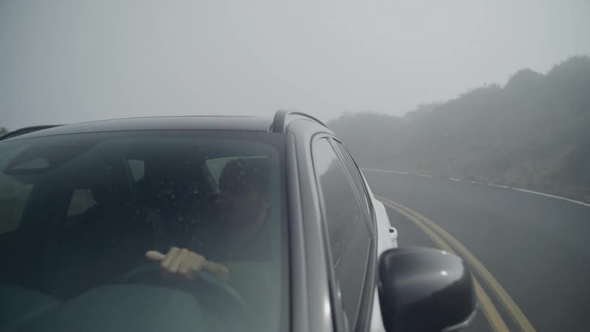 A man is turning around the corner on the road