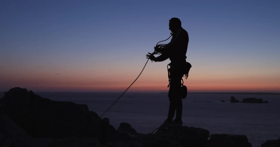 A mountain climber wraps up a rope