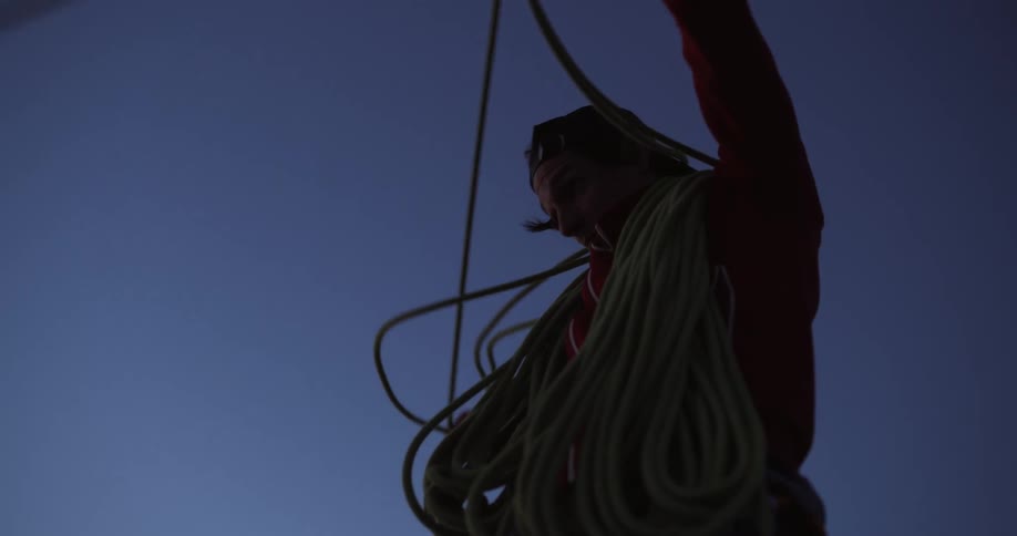 Man wraps long rope around their neck while organizing the rope