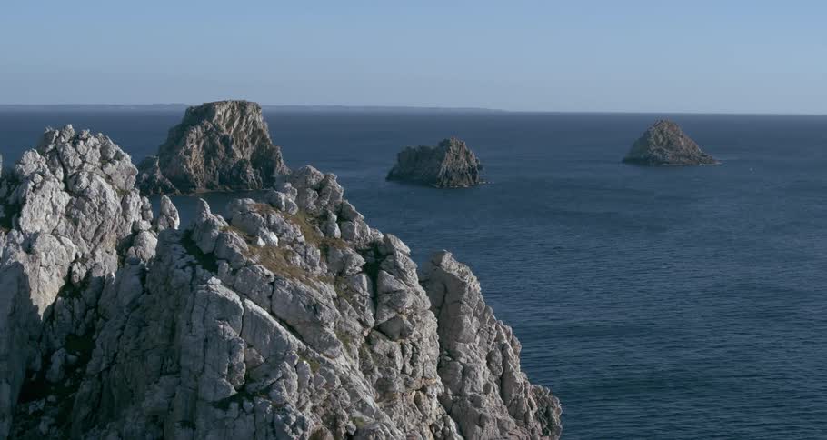 An ocean with series of rocks on top of it