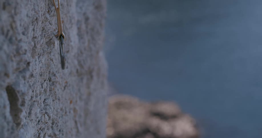 A climbing rope is pulled downwards on a cliff face
