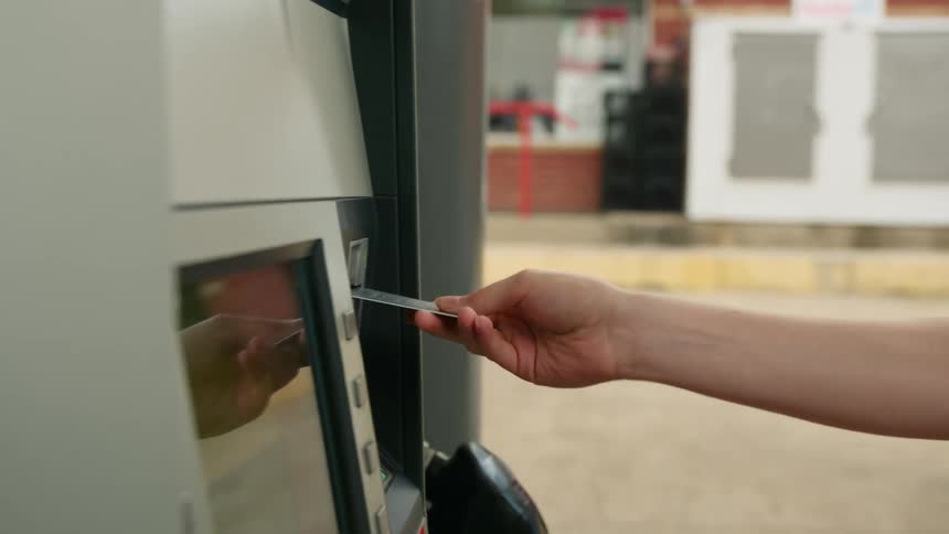 A person puts their credit card in the gas pump