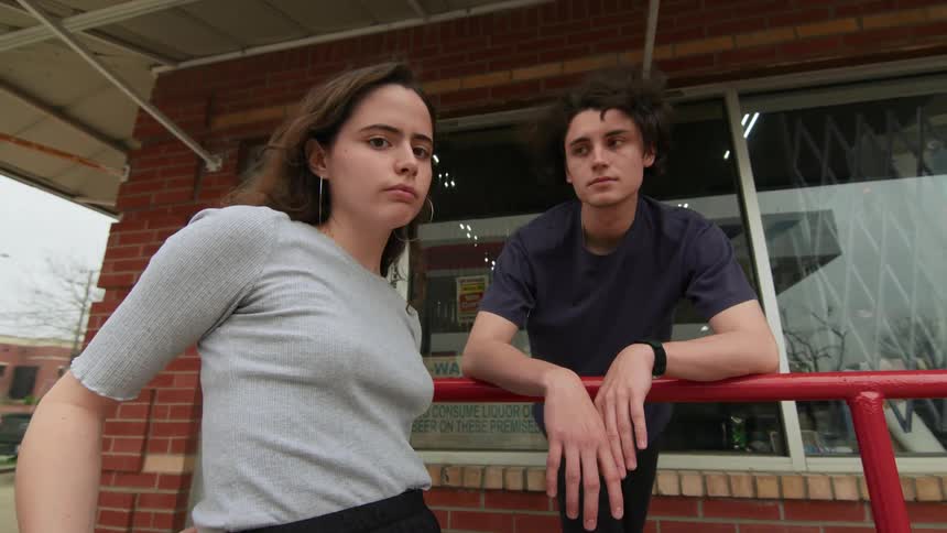 Man and woman pose together outside storefront