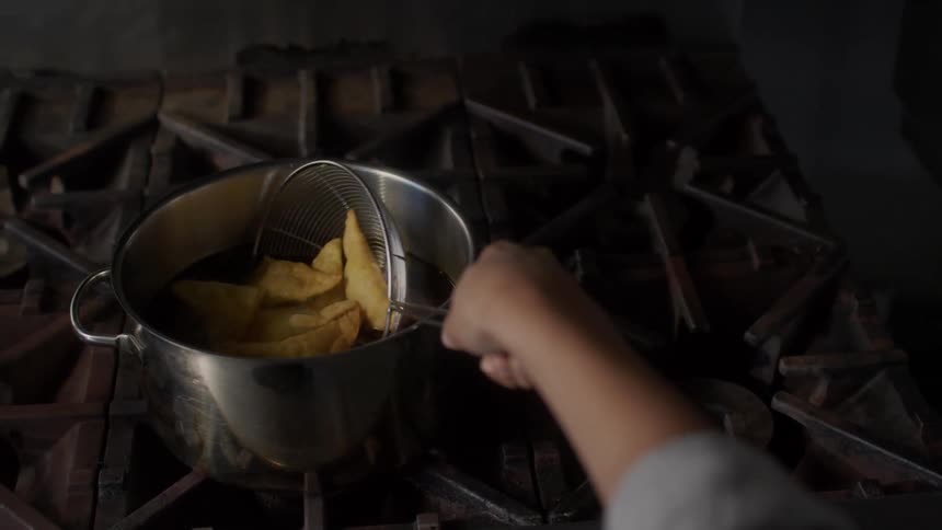 A person puts food into the hot oil