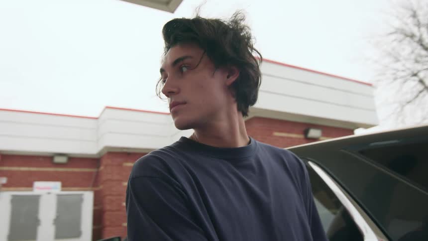 Portrait of a young man looking to the side at a gas station