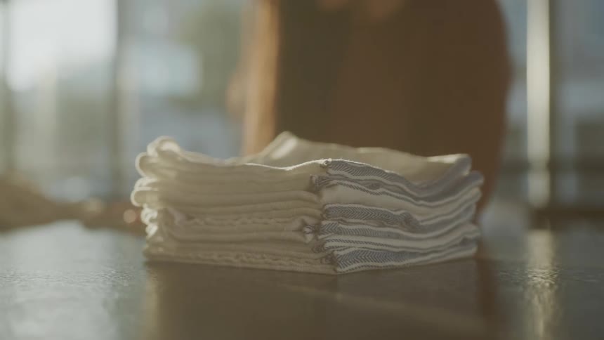 A woman folds and stacks napkins neatly