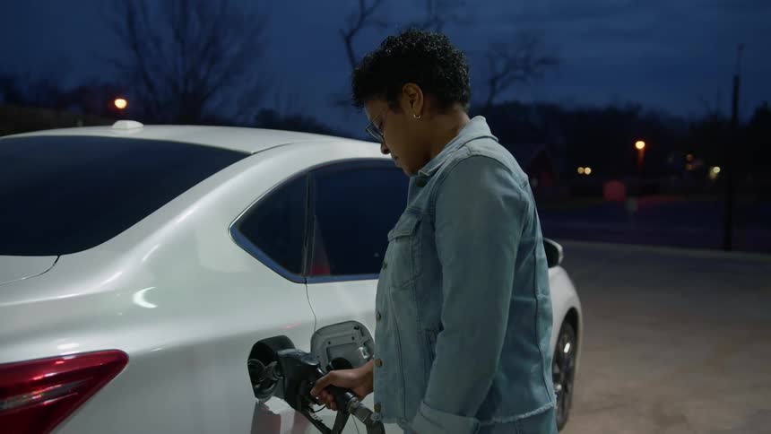 A woman pumps gas