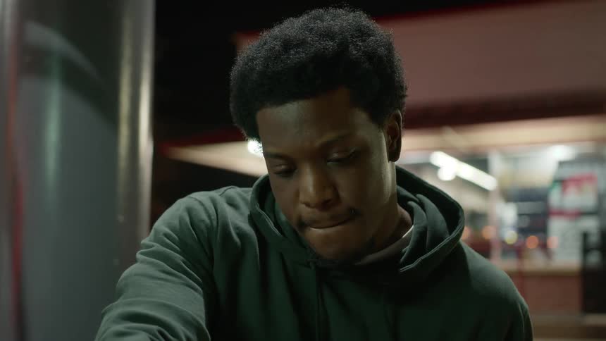 Portrait of a young man at a gas station at night