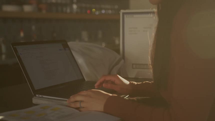 Young asian woman opening her laptop and working indoors with sunlight