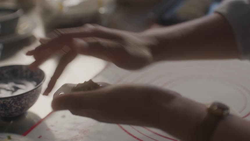 A chef is making dumplings in the kitchen