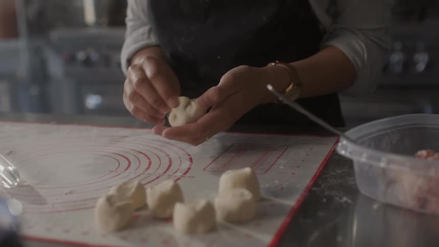 A woman is making dumplings in the kitchen