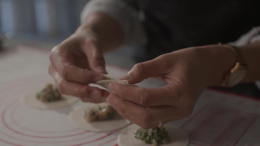 A woman kneads a piece of dough
