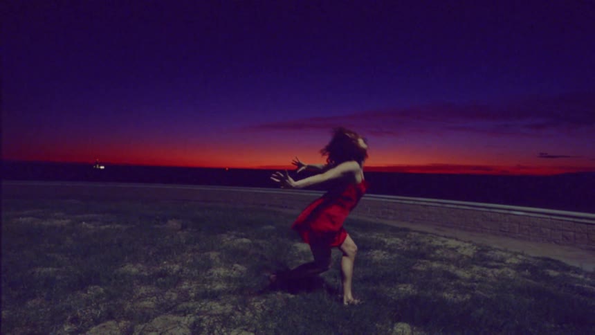 A woman is dancing by the shore