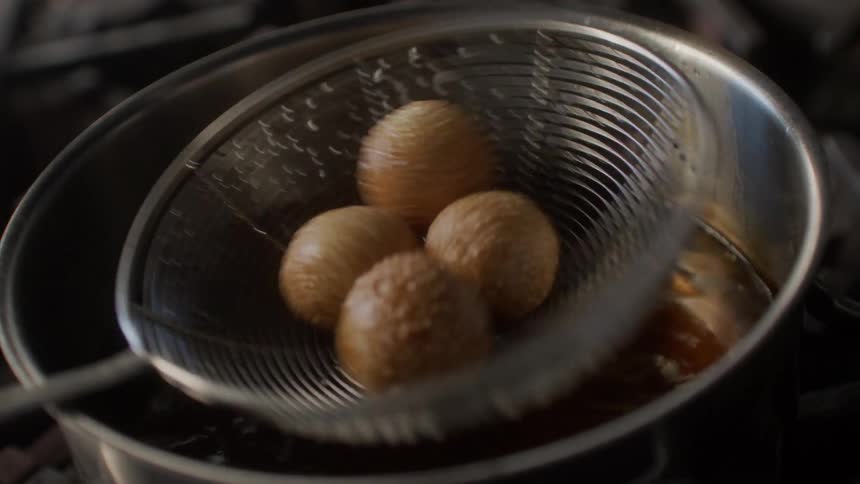 Food floating it pot is removed from pot by scoop and then shaken