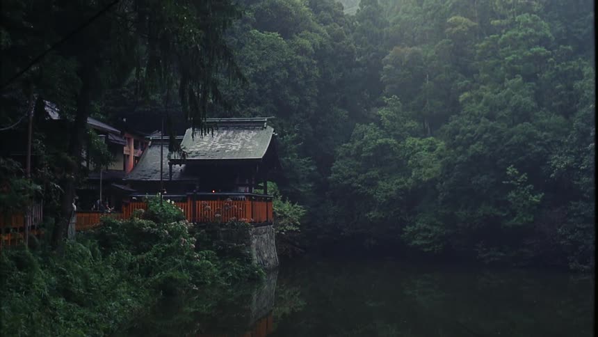 A small group of people visit a building next to a pond