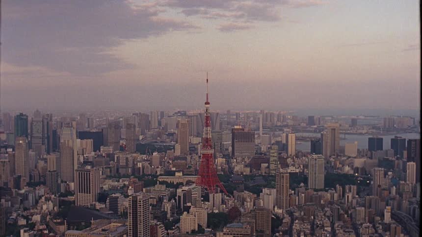 Red structure towers over coastal city on hazy day