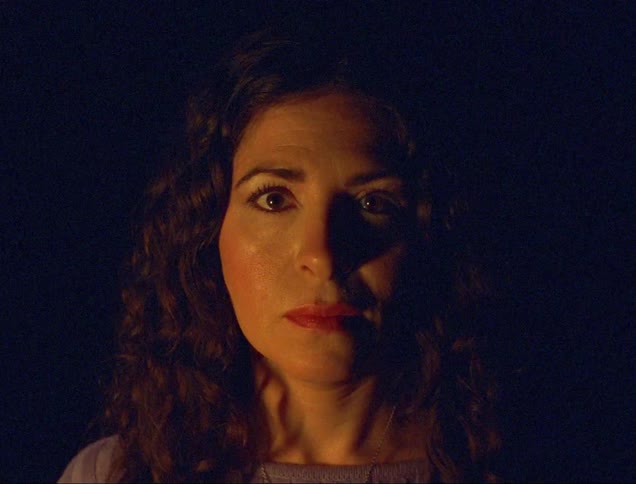 A woman is blinking in the dark