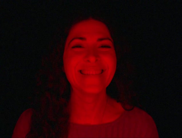 Close up of woman laughing under red lighting