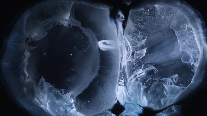 An abstract liquid expanding and compressing in a black environment