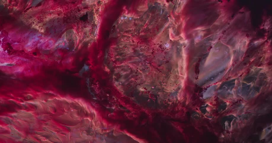 An abstract of red and black ink forming a cloudy membrane in liquid