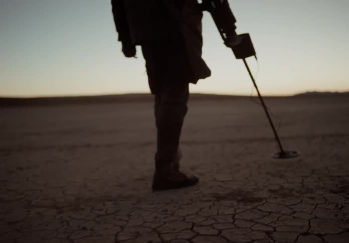 A clip of a man searching while scanning the soil