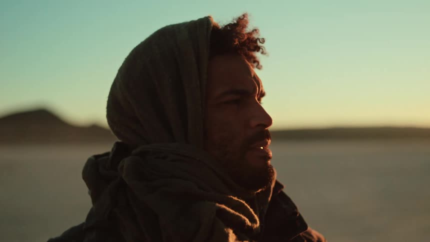 A man in a desert looks around