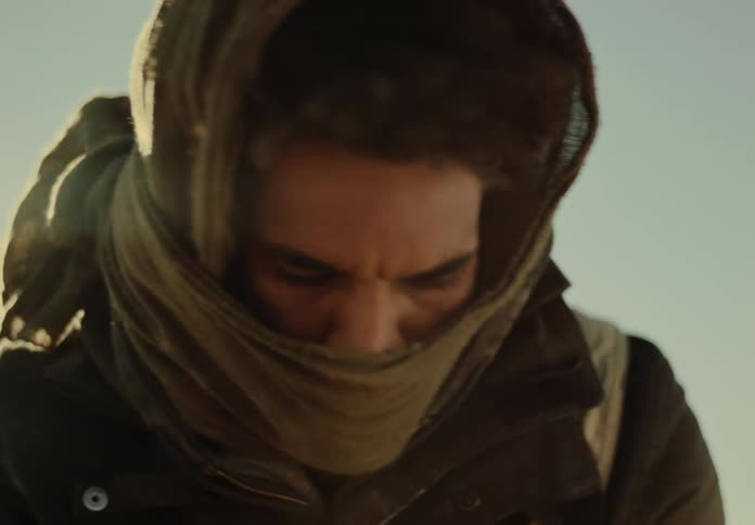 Man shifts to the right and left with his mouth covered by a scarf