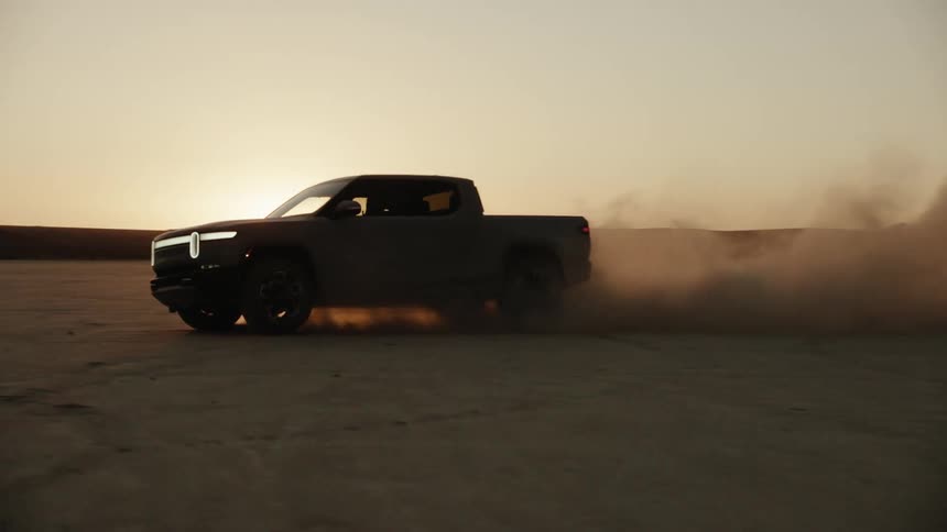 A truck leaves a dust cloud behind him as he drives in the desert