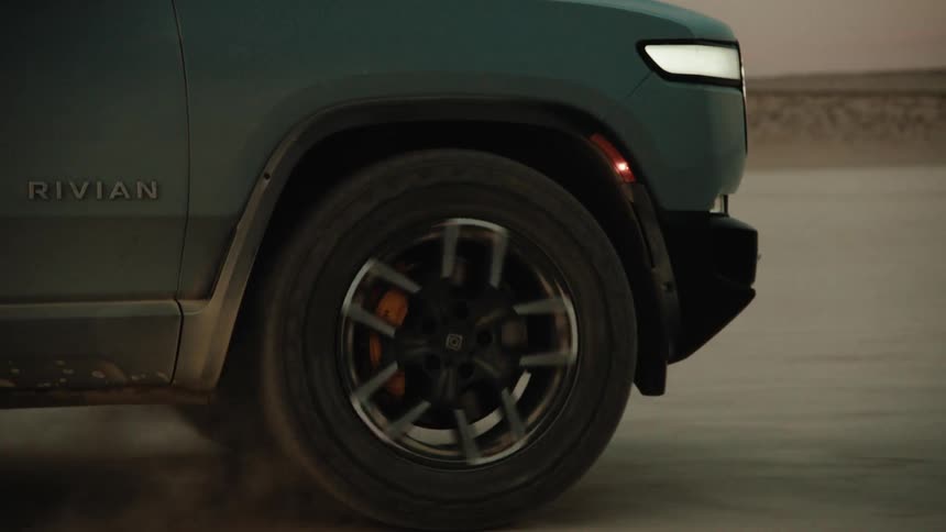 A rolling tire on a truck driving across a flat terrain