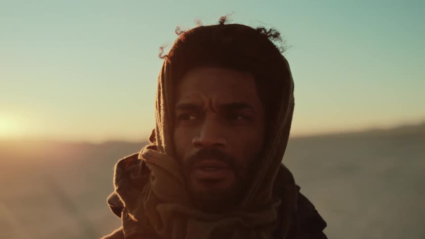 A man looks around in a desert