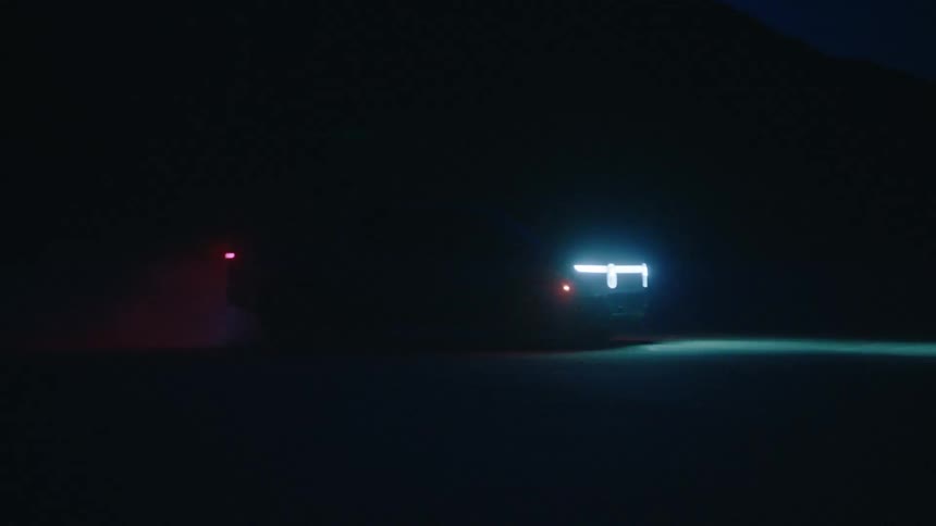 A truck driving outdoors at night