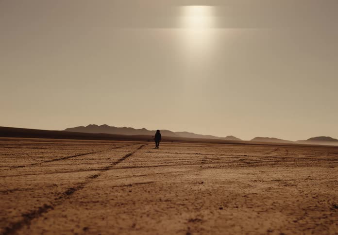 A person is walking alone in the desert