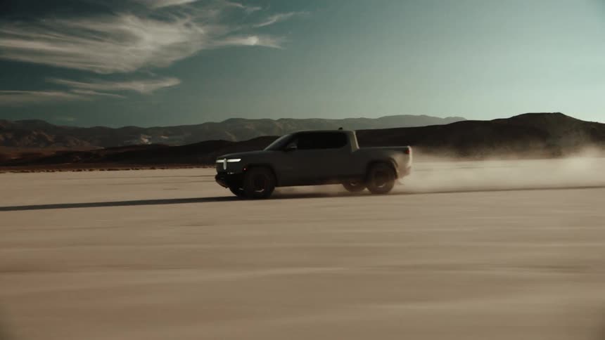 A pick up truck speeding across the desert sand