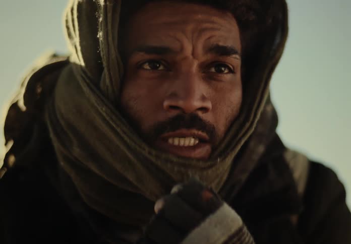 A man removes the scarf from his mouth