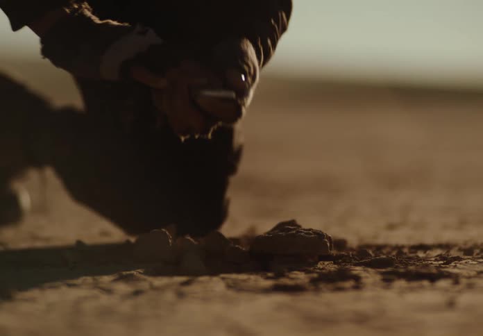 A man using a metal detector finds an object and digs it up
