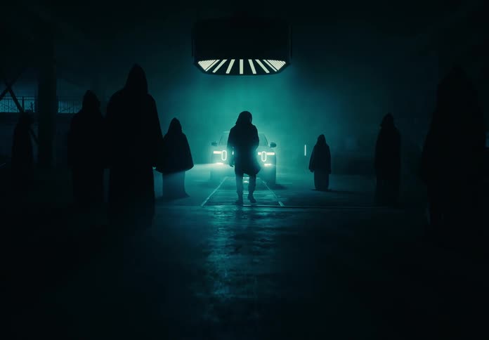 A group walk in front of the trucks headlights