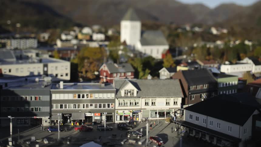 Cars and people move around a town near mountains