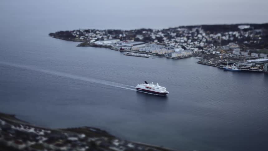 Cruise passing through a canal next to a city on an island in timelapse