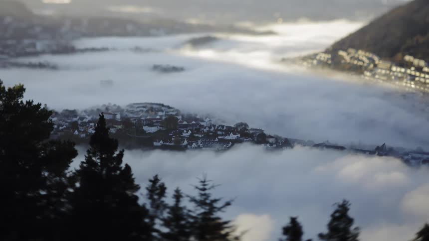 Clouds move over the city at the base of the mountain