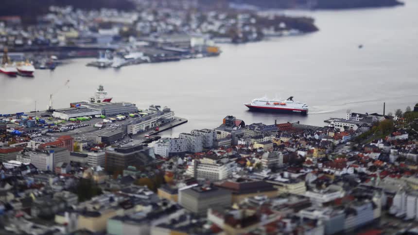 An aerial clip of a community close to the shore and a cruise ship docking