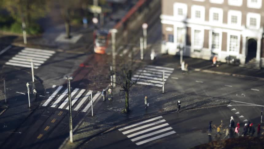 Pedestrians cross the street before a train passes