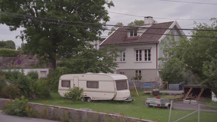 Motorhome in the backyard of a residential neighborhood on a cloudy day