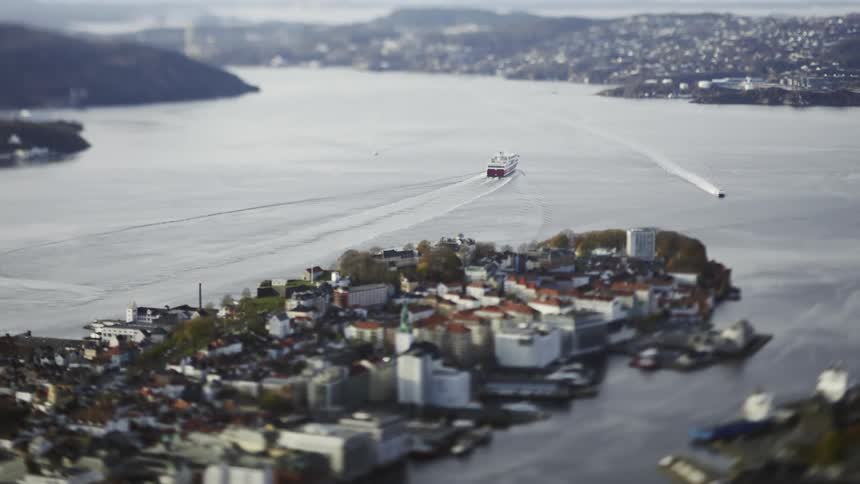 An aerial clip of an island and a cruise ship sailing away