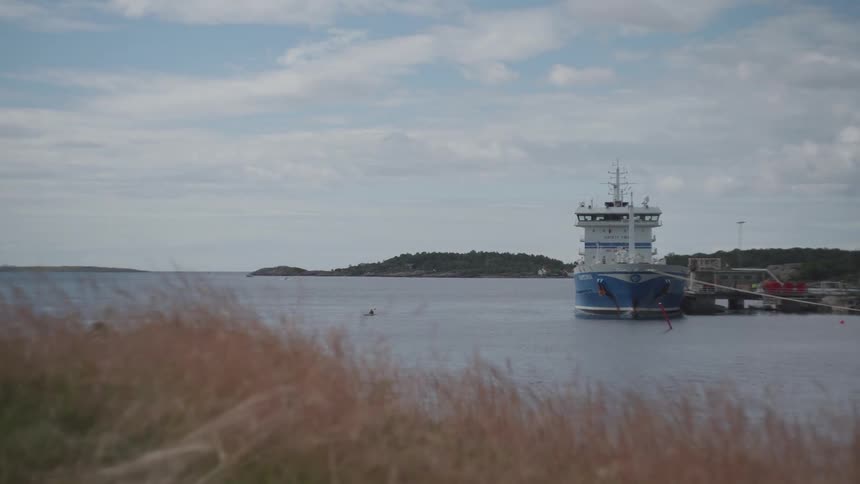 Ship attacked at a dock with islands and mountains on the horizon
