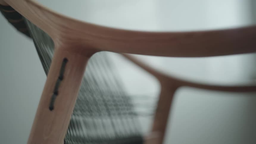 Closeup of the side of a wooden and black leather chair