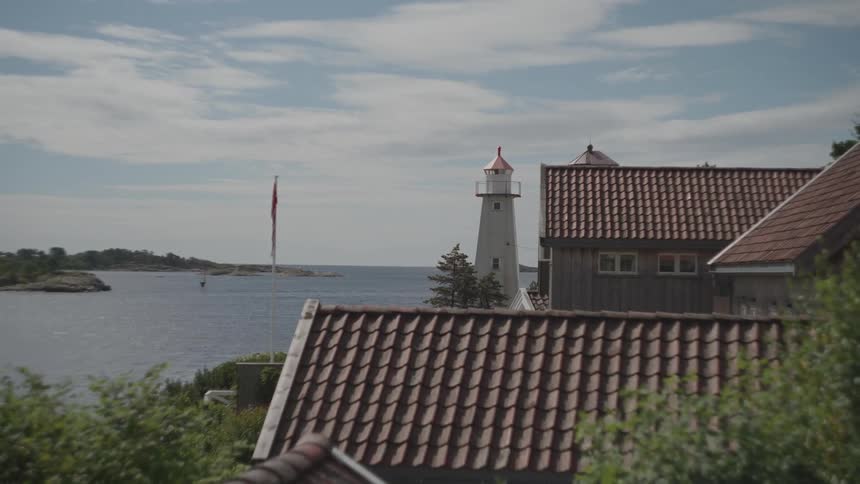 A lighthouse and homes on a coast